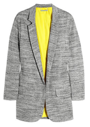 Her tweed blazer boasts a vibrant yellow lining that pops with rolled cuffs