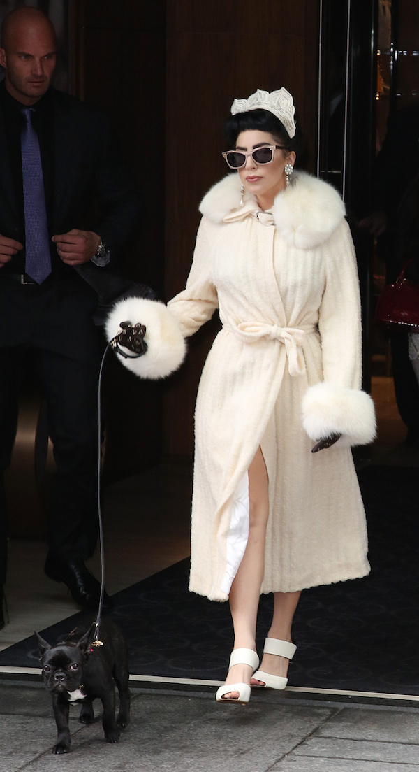 Lady Gaga wears a luxurious, furry robe and a crown as she leaves her hotel in Toronto