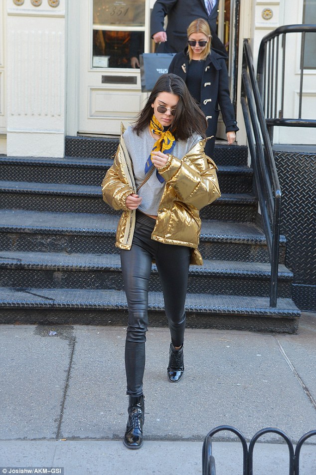 Kendall Jenner in a Ports 1961 metallic gold jacket, Kreme sunglasses,  Chanel scarf, RTA pants and Louis Vuitton Repu…