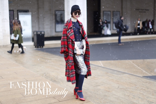 This fashionista topped a sequin skirt and navy blazer with a chic plaid coat. Image by Karl Pierre.