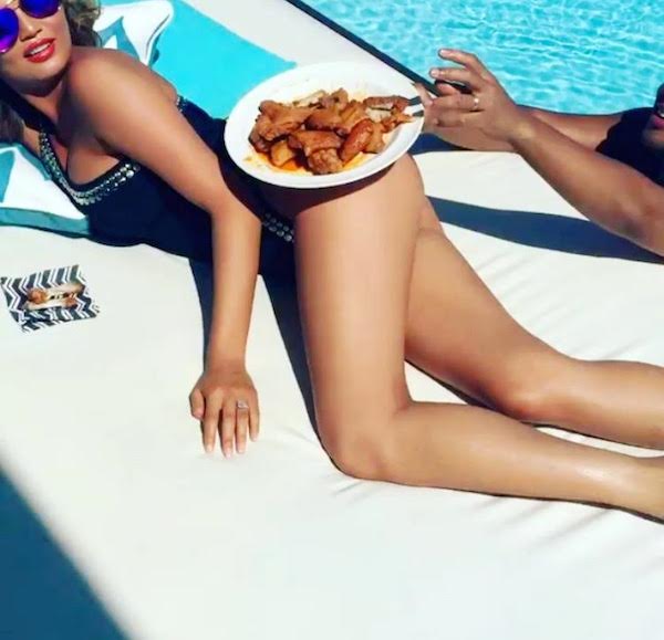 How cool is Chrissy Teigen with this Norma Kamali one shoulder embellished black bathing suit?