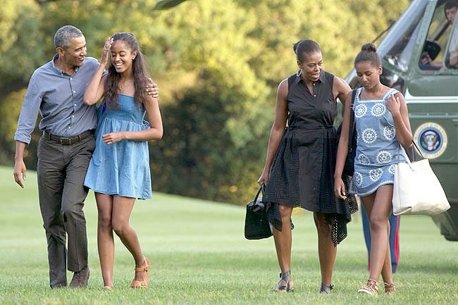 From left, President Barack Obama with daughter Malia and first lady Michelle Obama with daughter Sasha, walk form Marine One across the South Lawn of the White House in Washington, Sunday, Aug. 23, 2015, as they return form a family vacation on Martha抯 Vineyard. (AP Photo/Carolyn Kaster)