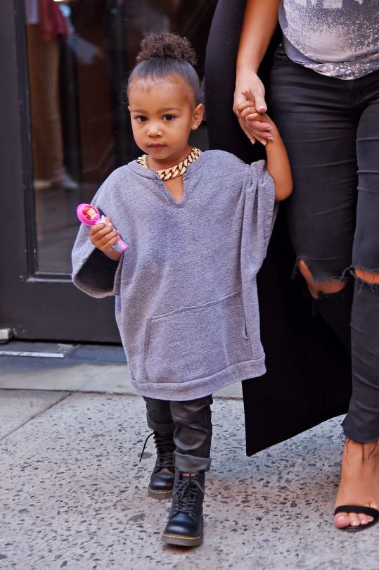 North West looked adorable in an oversize gray shirt, leather pants, and a chunky gold chain necklace.