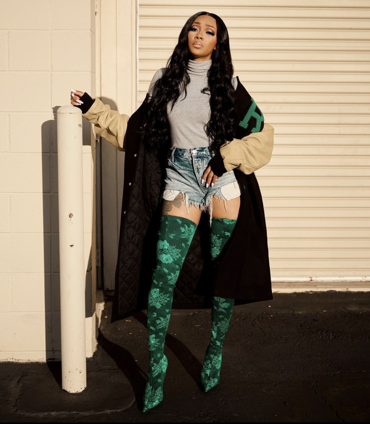 You We Answer! Rocks a $2,407 Raf Simons FW20 American Letterman Jacket and Balenciaga Green Floral Lace Thigh High