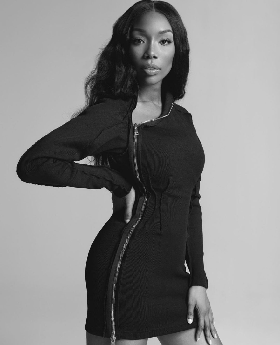 Brandy Stuns in Black and White Photoshoot Wearing Lionne Clothing Black Long Sleeve Zip Up Mini Dress and Femme LA Black Lace Up Sandals3
