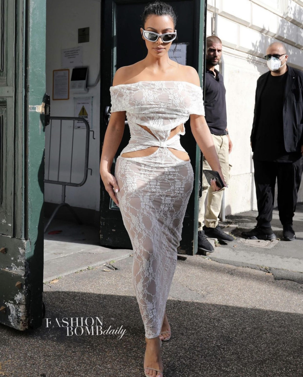 Kim Kardashian Visits the Vatican in Barragan White Off the Shoulder Cutout Sheer Lace Dress Balenciaga Sunglasses and Yeezy Nude Double Strap Sandals