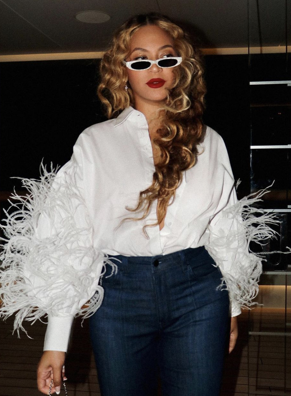 Beyonce Spotted Yachting in Capri With Jay Z Wearing Valentino White Feather Shirt Flare Leg Jeans PHILO White Sunglasses and Judith Leiber Martini Clutch2