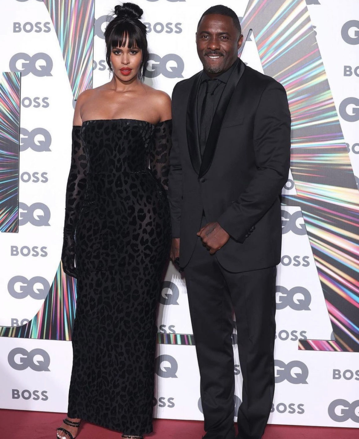 Sabrina Elba Stuns in Alex Perry Black Velvet Off Shoulder Leopard Print Dres at GQ Awards 2021 With Idris Elba