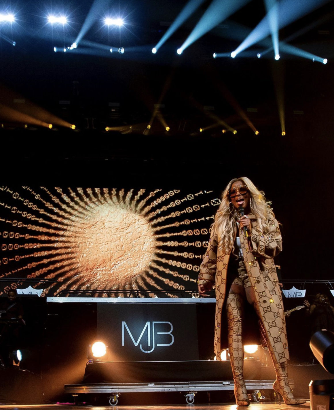 Mary J. Blige Performs at Barclays Center Wearing Gucci Fall 2021 Monogram Crystal Embellished Coat Shorts and Balenciaga Collaboration Thigh High Boots
