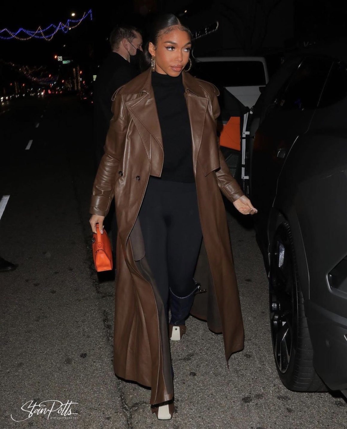 Lori Harvey Grabs Dinner in Beverly Hills Wearing Bottega Veneta Brown Leather Trench Coat Wolford Black Top and Leggings and Louis Vuitton Colorblock Knee High Wedge Boots