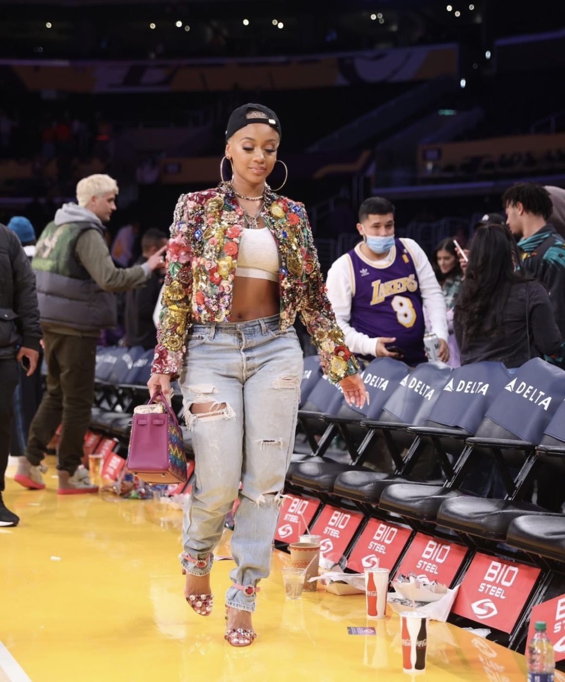 Saweetie Attends Lakers vs. Timberwolves Game in LA Wearing Dolce and Gabbana Embellished Jacket and Pink Heels Paired with White Crop Top Distressed Jeans and Goodie Black Hat5