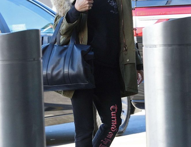 Splurge: Hailey Baldwin’s JFK Airport $4,590 Saint Laurent Green Hooded Parka, $550 Vetements Black Turned On By Danger Pants, and $435 Alexander McQueen Exaggerated Sole Sneakers