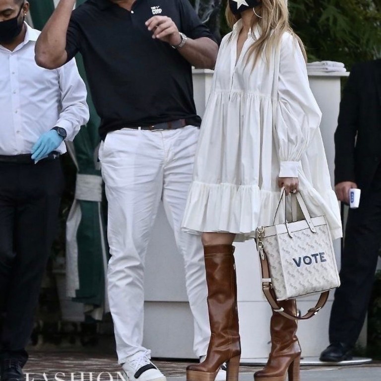 Jennifer Lopez Spotted In White Valentino Puff-Sleeve Tiered Shirt Dress Paired with Coach Custom ‘Vote’ Field Tote and Brown Pre-Fall 1941 Platform ‘Turbo’ Boots