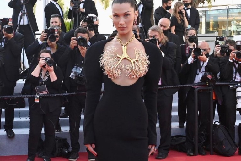 Bella Hadid Turns Heads at 2021 Cannes Film Festival Wearing Jean Paul Gaultier Black and White Dress and Schiaparelli Long Sleeve Black Dress With Gold Lungs Necklace