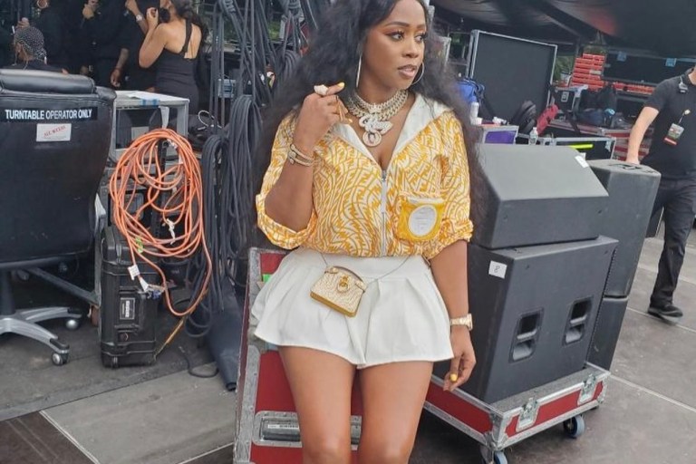 Remy Ma Performs at ‘We Love NYC’ Concert Wearing Fendi Yellow and White Logo Jacket, Purse, and Socks Paired With Ms. Bling Pleated White Mini Skirt and Chanel PVC Boots