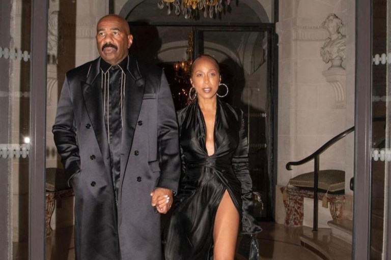 Marjorie and Steve Harvey Serve All Black Style Moment During Night Out in Paris: Marjorie Wears Alexandre Vauthier Black Satin Wrap Dress and Steve Wears Fendi Fall 2021 Black Satin Coat and Striped Shirt With Dolce and Gabbana Leather Pants