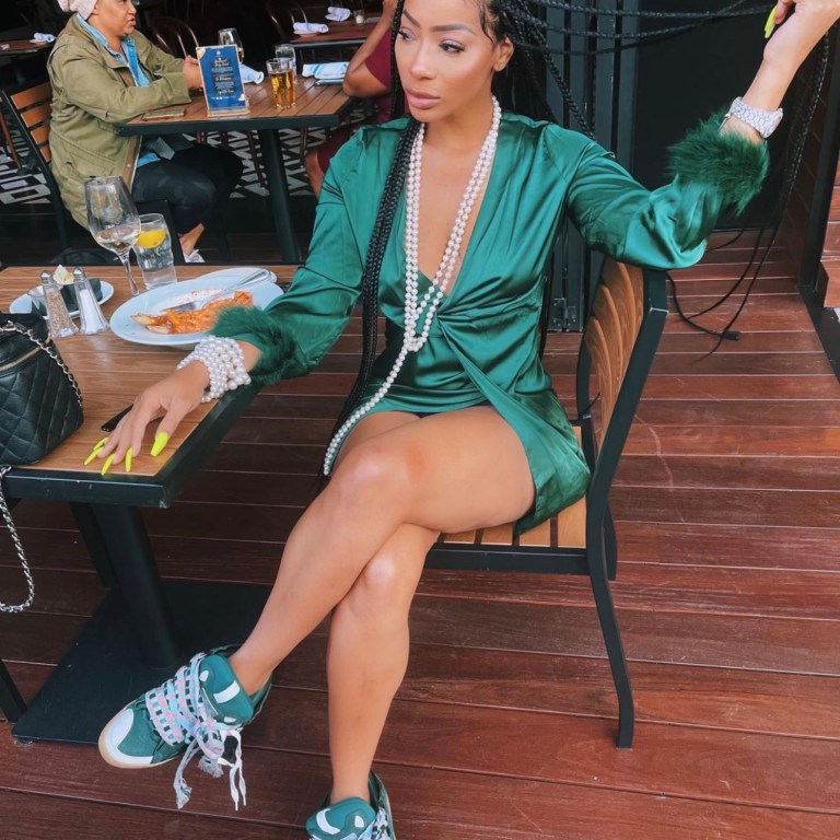 Tommie Lee Wears Green Feather Trim Satin Dress by Fashion During Latest Outing