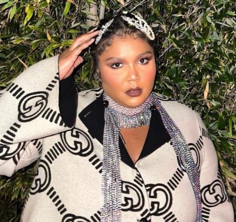 Lizzo Attends the Gucci Love Parade Wearing the Brand’s Reversible Logo Maxi Coat, Black Mini Tote Bag, and Monogram Slingback Pumps