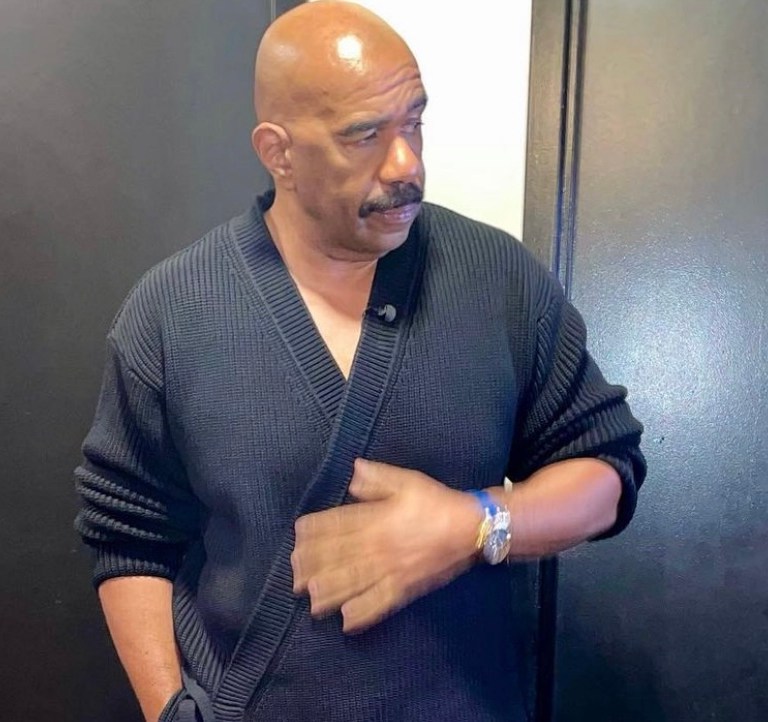 Steve Harvey Appears on ‘Jimmy Kimmel Live’ Wearing Dunhill Black Wrap Cardigan Paired With Gucci Black Monogram Leather Pants and Bottega Veneta Boots