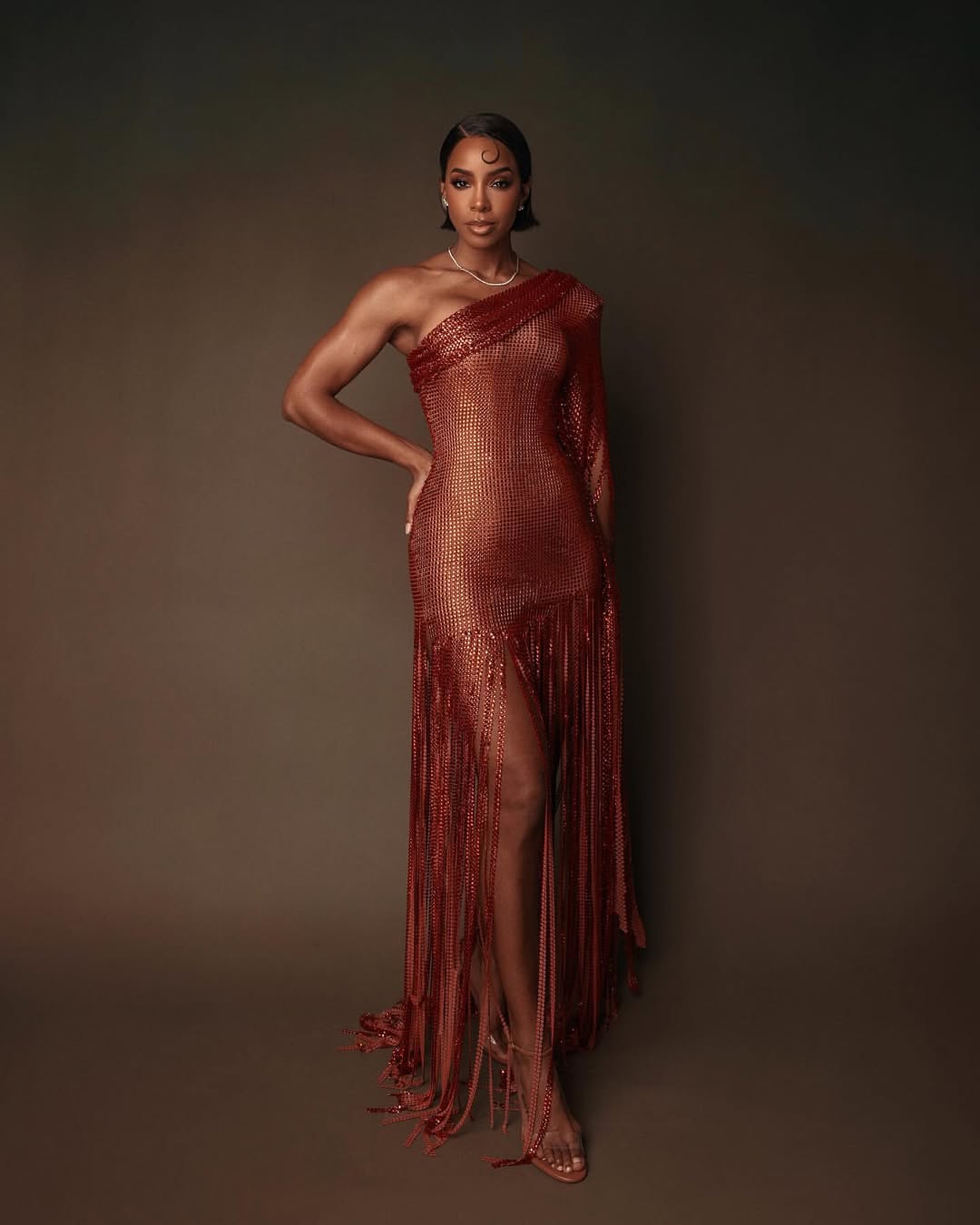 Kelly Rowland Posed In An Orange Chocolate Valdrin Sahiti Gown With Flor De Maria Sandals 1