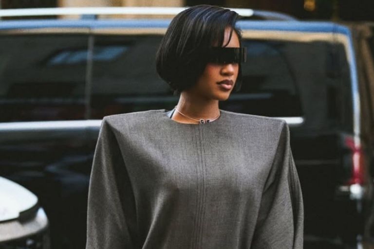 Milan Fashion Week: Saweetie attended the MM6 Maison Margiela Runway Show in a Gray Structured Dress with Black Gloves and Tan Boots